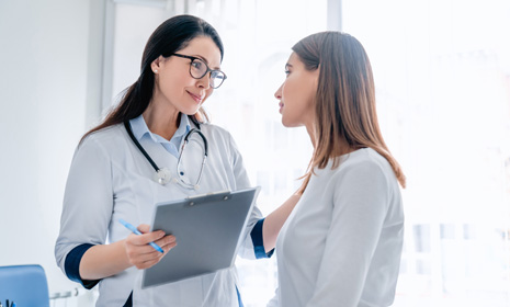 Healthcare professional consulting patient with clipboard